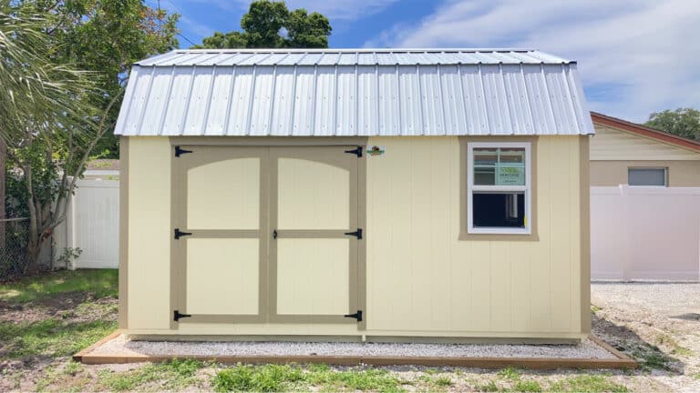 beige shed anchored on gravel