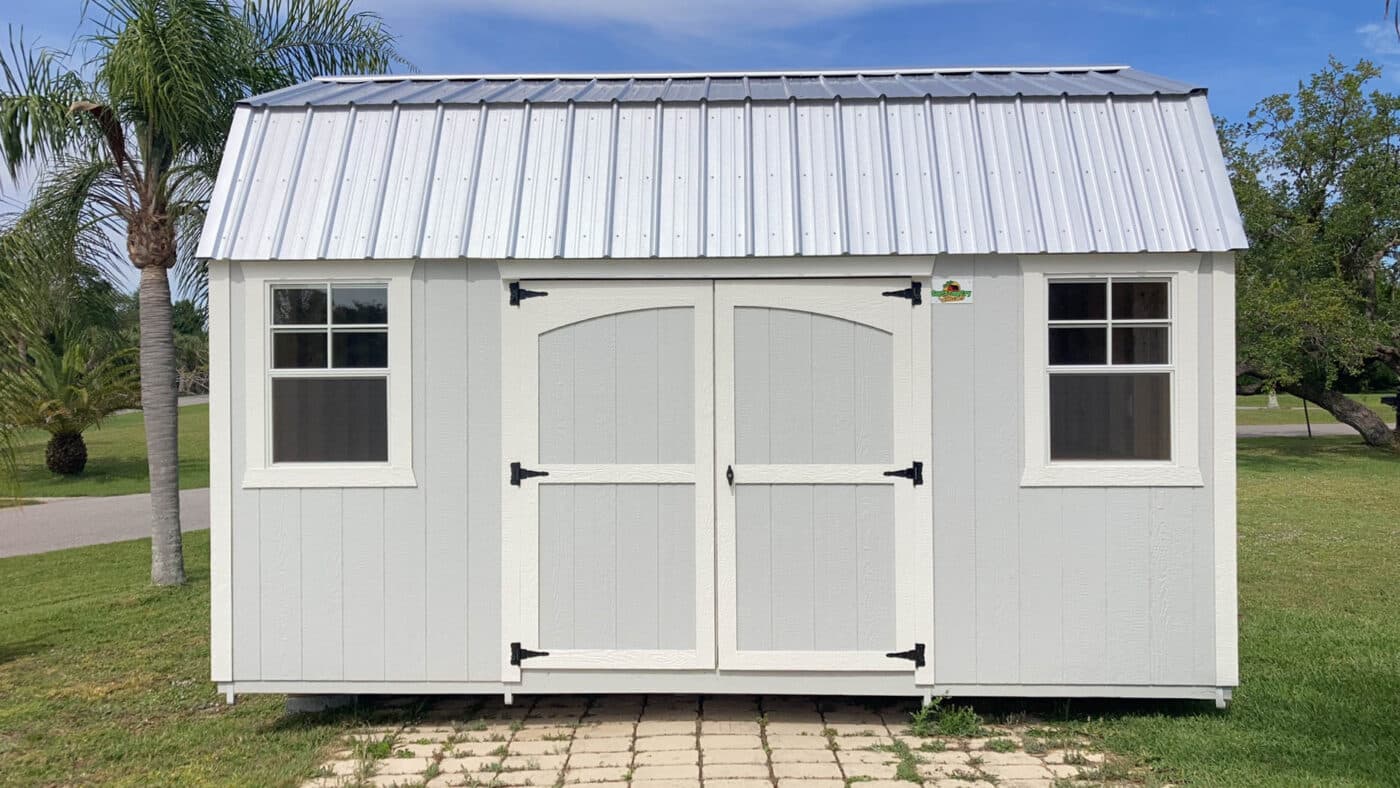 a white shed with white trim and a metal roof in florida