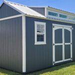 a grey shed with a dormer with transom windows in belle glade fl